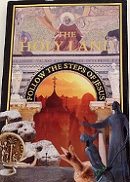 a book called "The Holy Land - Follow the Steps of Jesus" with a picture of archaeological findings, statues, the outline of buildings and medieval artwork