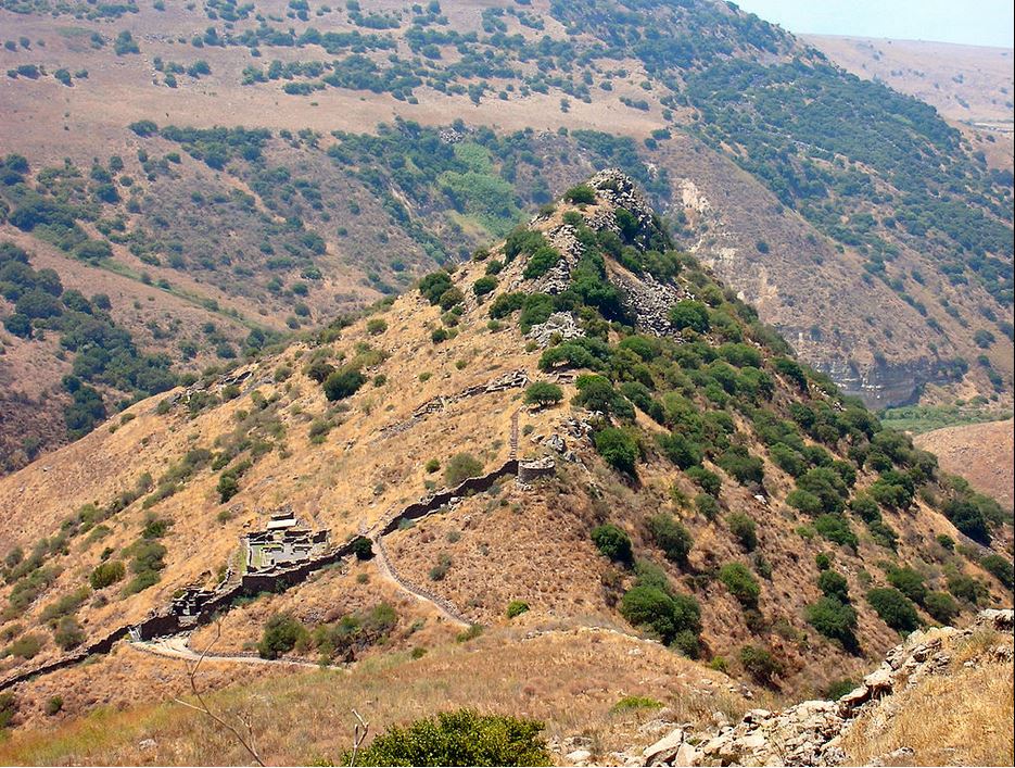 a hill called Gamla in Israel that has a sharp point and steep sides, especially on the left, with remaining outlines of a synagogue and defense walls