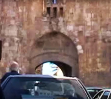 a picture of the tops of cars in front of a gate of the old city of Jerusalem