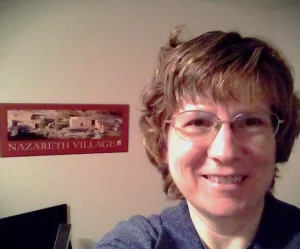 Heather with a picture behind her of Nazareth Village